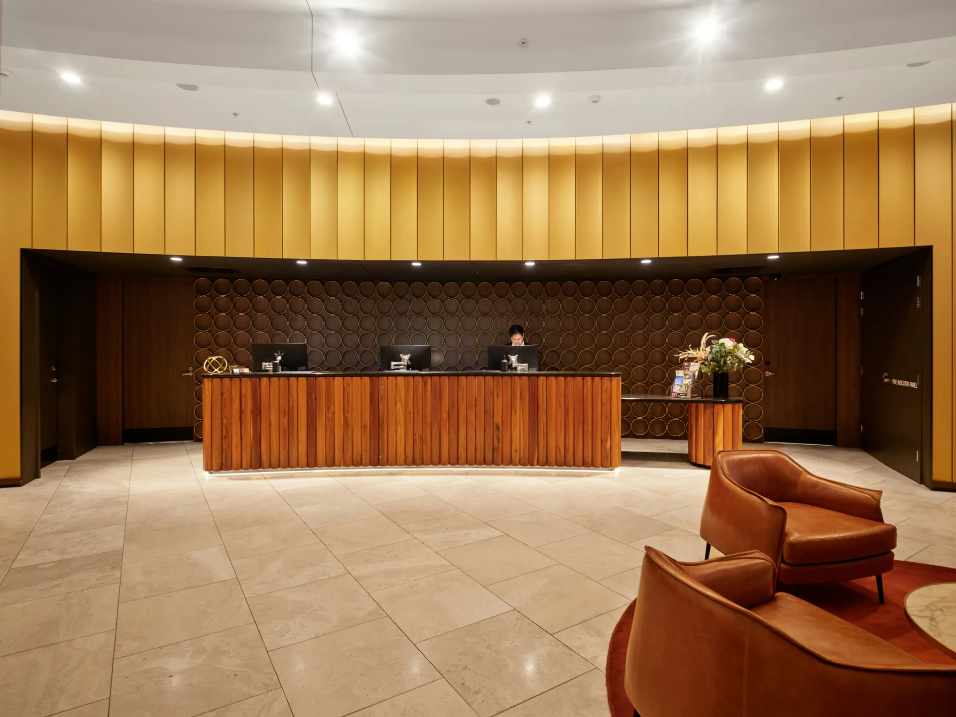 The reception desk of a quiet hotel lobby under warm lighting